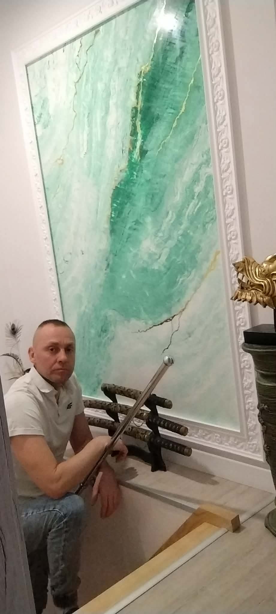 Rafał Kiełb przy ścianie z zielonego stiuku weneckiego ze złotymi żyłami